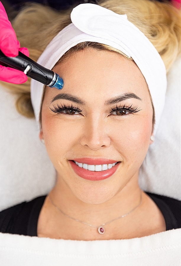 Woman receiving a facial treatment with a device.