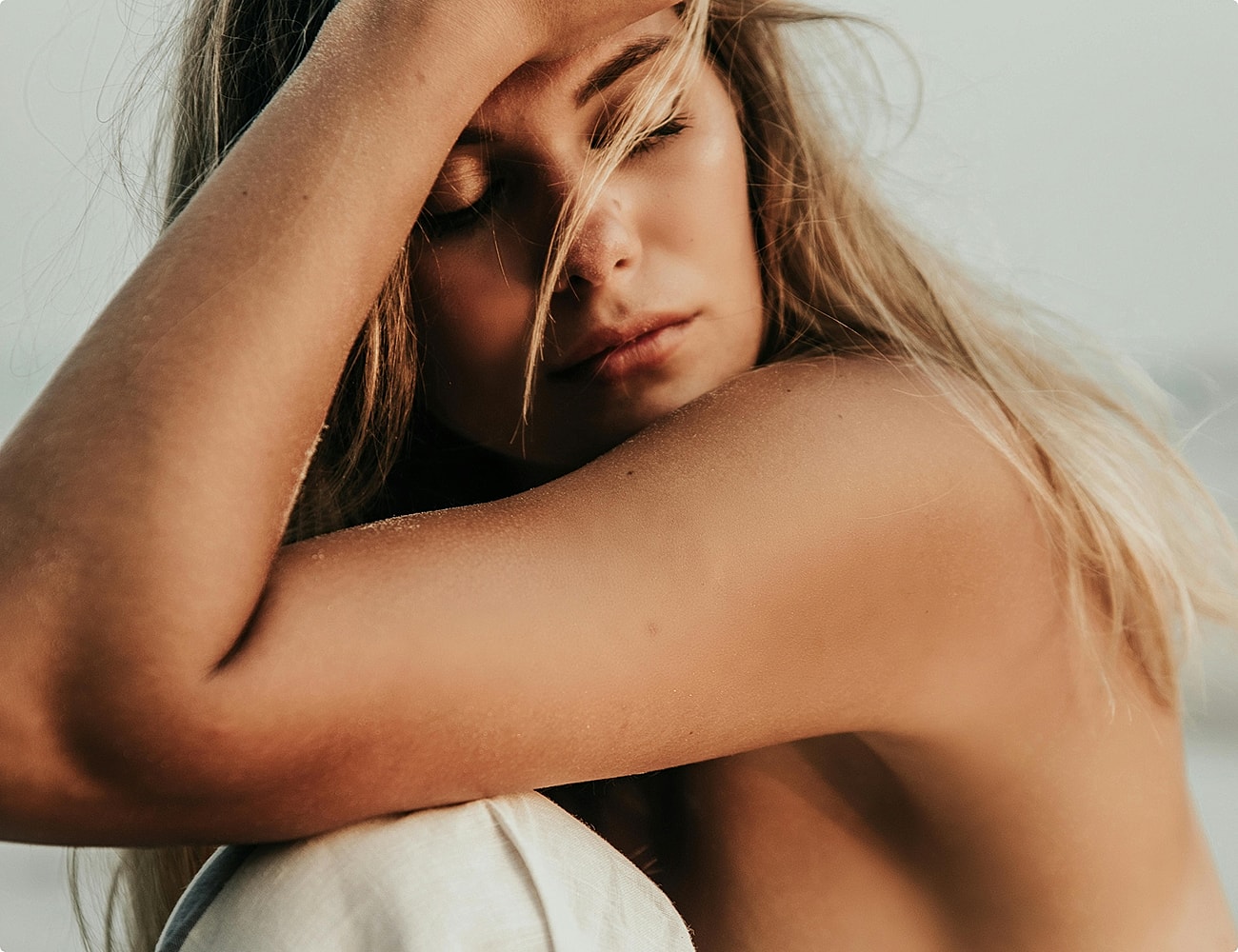 Woman smiling in sunset by the beach.