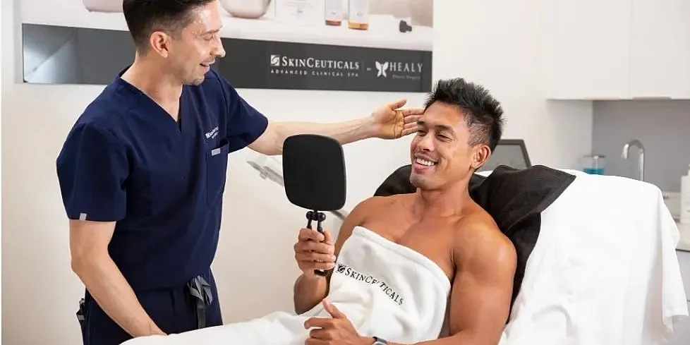 Man receiving skincare treatment in clinic.