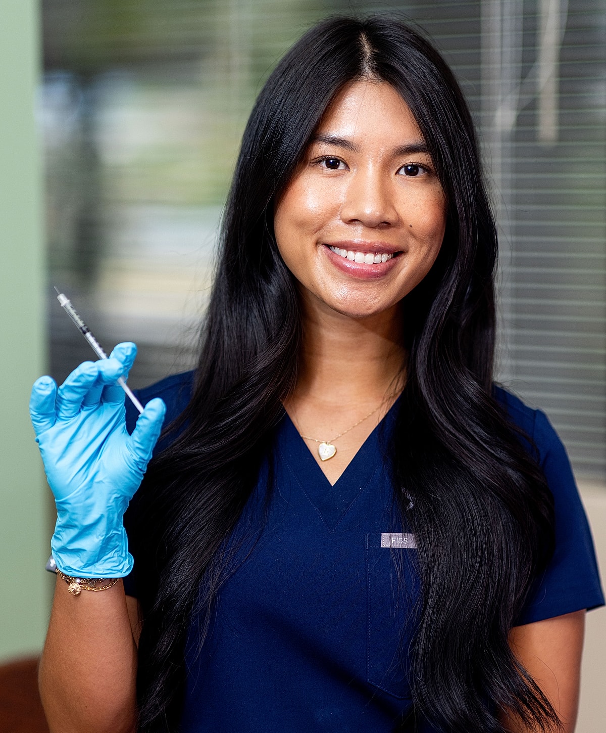 Smiling woman in white dress by a pool.
