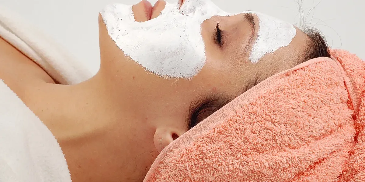 Woman relaxing with facial mask treatment.