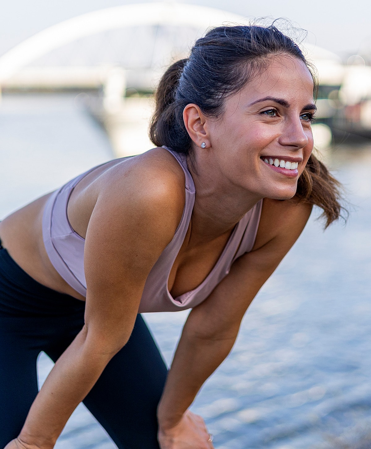 Smiling woman exercising by the water.