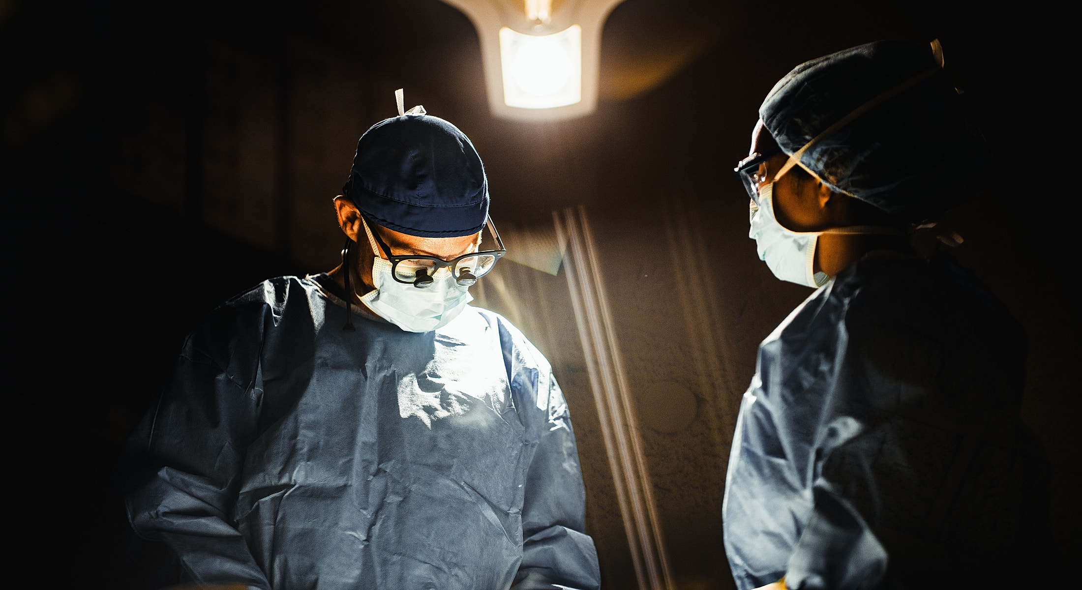 Surgeons focusing in an operating room environment.